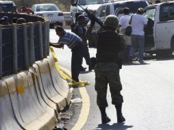 Un soldado monta guardia en el sitio donde el jefe de la Zona Norte de Guerrero y sus escoltas fueron atacados. EFE  /