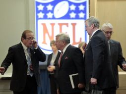 Algunos de los dueños de la NFL charlan a las afueras del hotel donde negociaban ayer con el Sindicato de Jugadores. AP  /