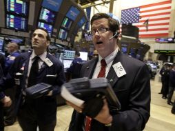 Traders Gregory Rowe a la izquierda y Christopher Forbes trabajando juntos en Nueva York, en el piso del Wall Street. AP  /