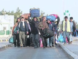 Tunecinos en Libia cargan sus pertenencias y caminan por la frontera para intentar regresar a su país. REUTERS  /