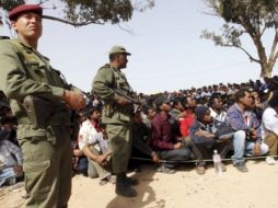 Soldados tunecinos vigilan a los trabajadores de Bangladesh que han huido de Libia en el campamento de ACNUR. EFE  /