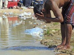 Un refugiado se limpia en las aguas de un charco en la zona fronteriza entre Libia y Túnez. REUTERS  /