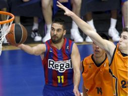 Gustavo Ayón, al fondo, intenta evitar una anotación del jugador del Regal Barcelona. EFE  /