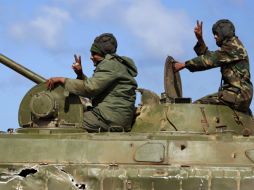 Rebeldes libios hacen señales de victioria a bordo de su tanque. AP  /