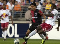 Salou Ibrahim lucha con Gerardo Flores por la posesión del balón en el encuentro que empataron 1-1 Atlas y Red Bulls. EFE  /