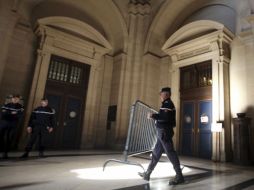 Un policía coloca una valla en la entrada del Tribunal Correccional de París. EFE  /
