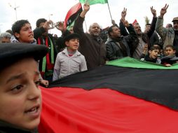 Varias personas sostienen una bandera pre-Gadhafi durante una multitudinaria manifestación. EFE  /