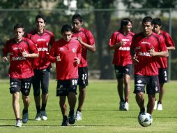 Elementos del primer equipo rojinegro trotan ligeramente en la cancha de Colomos. MEXSPORT  /