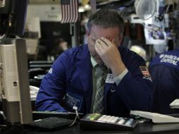 Especialista Christopher Culhane trabaja en su puesto en el piso de la Bolsa de Nueva York. AP  /