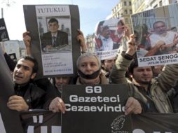 Periodistas muestran retratos de compañeros detenidos durante la manifestación en Estambul Turquía. EFE  /
