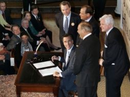 Mitt Romney, sonríe con el Secretario Timothy Murphy. AP  /