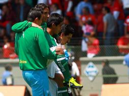 Fernando Arce (c.) es ayudado por el cuerpo médico de Santos para salir de la cancha. MEXSPORT  /