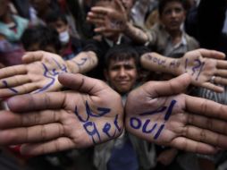 Protestantes anti Gobierno muestran las manos con un escrito en árabe, alusivo a la dimisión de Alí Abdulá Saleh. AP  /