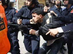 Fuerzas del orden someten a un activista  islamita en Casablanca, afuera de la sede del Partido Socialista Unificado. AP  /