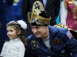 El astronauta Scott Kelly posa para una fotografía acompañado de una niña. AFP  /