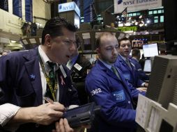 Los comerciantes se reúnen en el piso de la Bolsa de Nueva York. AP  /