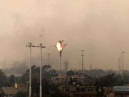 Un avión abatido sobre Bengasi desciende envuelto en llamas. AFP  /