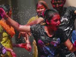 Un grupo de jóvenes se divierte con agua y tintes de colores durante la celebración de la fiesta. EFE  /