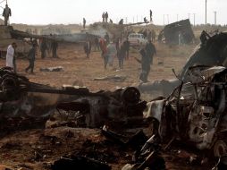 En Bengasi, personas observan los daños ocasionados a tanques del régimen libio luego de un ataque de la coalición aliada. REUTERS  /