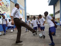 Barack Obama juega con un niño durante su recorrido por la favela ''Ciudad de Dios'', en Río de Janeiro. REUTERS  /
