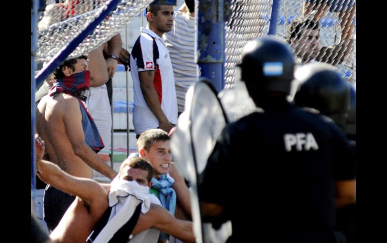 Elementos de seguridad tratan de impedir la entrada de los aficionados a la cancha del estadio de Vélez. EFE  /