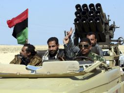 Rebeldes libios hacen el signo de la victoria mientras recorren la carretera que comunica Ajdabiya con Bengasi. EFE  /