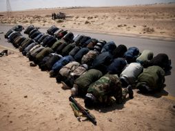 Soldados rebeldes libios oran antes de los combates en la ruta cerca a Ajdabiya. EFE  /