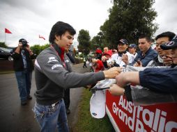Sergio Pérez firma autógrafos, previo a su primer entrenamiento como piloto de Formula 1. EFE  /