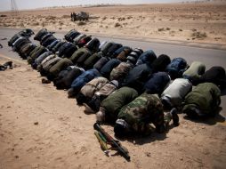 Soldados rebeldes libios oran antes de los combates en la ruta cerca a Ajdabiya, en Libia. EFE  /