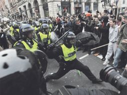 Agentes antidisturbios enfrentan a un grupo de manifestantes en Londres. EFE  /