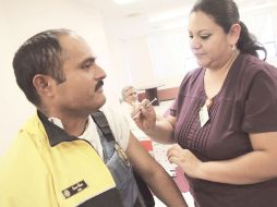 Un integrante de la Secretaría de Tránsito y Vialidad en Chihuahua es vacunado contra el virus de la influenza humana. EFE  /