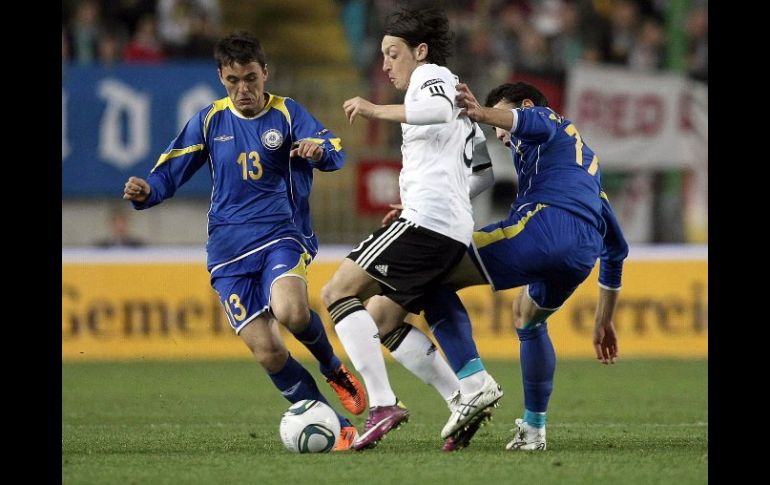 El alemán Mesut Özil (centro) lucha por el control del balón con jugadores de la selección de Kazajistán. EFE  /