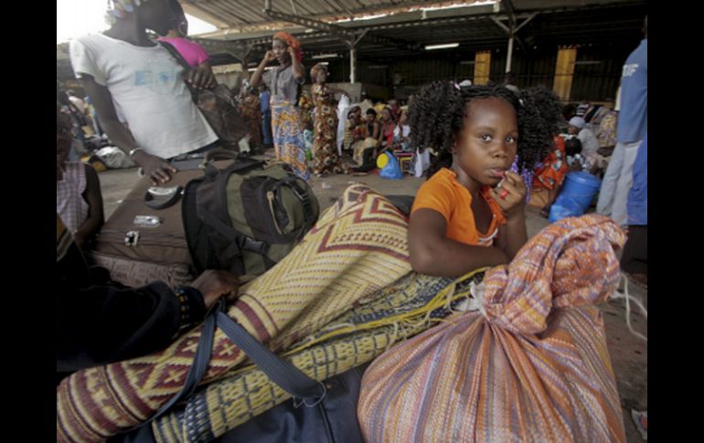 Marfileños se concentran en una estación de buses para salir de Abidján. EFE  /