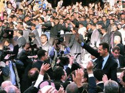 El mandatario Bashar al-Assad saluda a simpatizantes, en Damasco. AFP  /