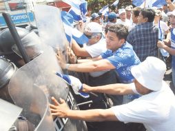 Opositores al Gobierno nicaragüense forcejean con antimotines en Managua. REUTERS  /