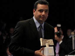 El mexicano sostiene el premio obtenido por su trabajo en Haití. NTX  /