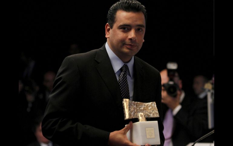 El mexicano sostiene el premio obtenido por su trabajo en Haití. NTX  /