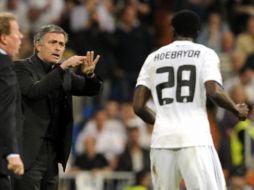 El técnico de los merengues, José Mourinho, da instrucciones al goleador del partido ante Tottenham, Emmanuel Adebayor. AFP  /
