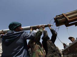 Rebeldes cargan un lanzamisiles desde su posición en una carretera que conduce hasta Brega. REUTERS  /