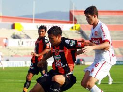 Miguel Martínez (i.), de Jaguares, controla el balón ante la marca brasileña. MEXSPORT  /