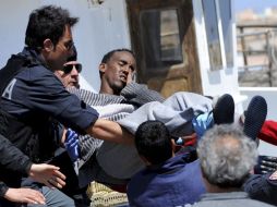 Socorristas ayudan a un herido procedente de Libia, al llegar a Lampedusa, Italia.  /