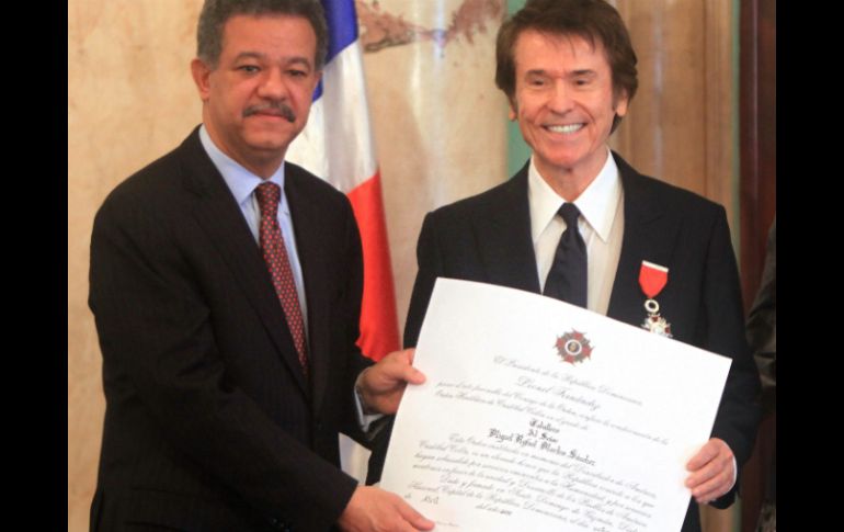 Leonel Fernández (i), condecora al cantante español Raphael (d) con la Orden Heráldica de Cristóbal Colón. EFE  /