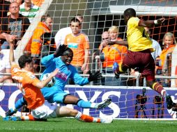 Emmanuel Eboue (derecha) dispara a la portería del Blackpool y consigue un tanto para el Arsenal. REUTERS  /