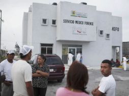 Varias personas esperan afuera del Semefo para averiguar si sus familiares están entre los restos mortales encontrados. AP  /