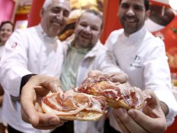 Dos cocineros muestran un pan con jamón, promocionando el desayuno español. EFE  /