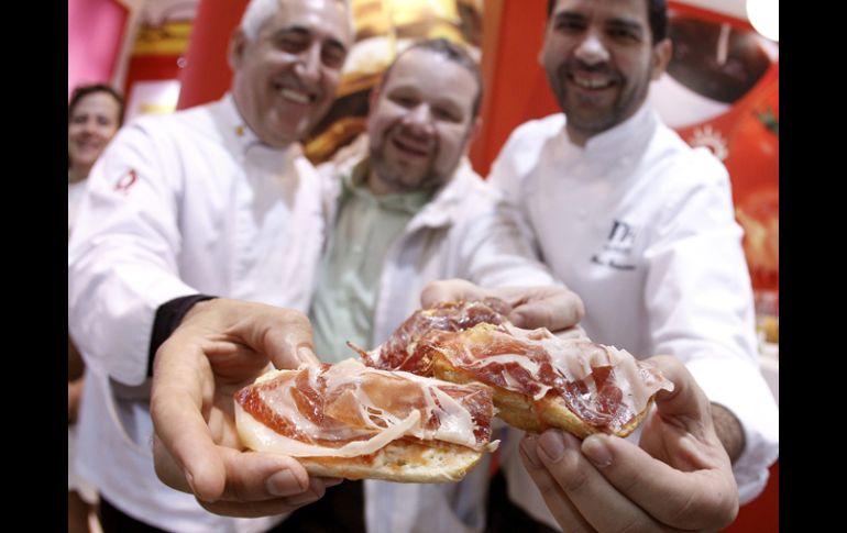 Dos cocineros muestran un pan con jamón, promocionando el desayuno español. EFE  /