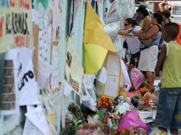Familiares depositan flores en una pared de la escuela municipal Tasso da Silveira, en Río de Janeiro. AFP  /