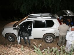 Aspecto de la labor de policías en el aseguramiento de armas y vehículos tras el enfrentamiento en Ayotlán. O. RUVALCABA  /