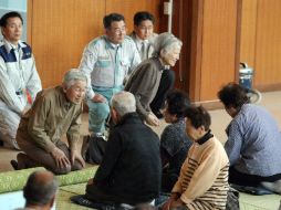 El emperador de Japón, Akihito, visitó las zonas afectadas por desastres naturales y conversó con los daminificados. AFP  /