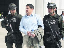 Policías de la Dirección Central de Inteligencia escoltan a José Guillermo Gallón (centro), para ser extraditado a Estados Unidos. AFP  /